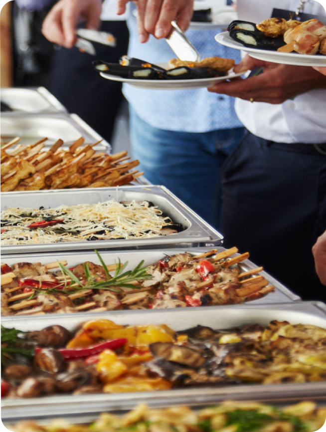 Four employees meeting over a catered lunch laughing Four employees meeting over a catered lunch laughing