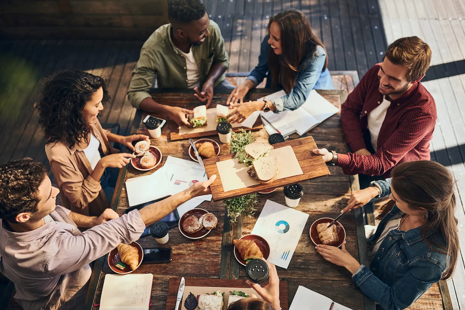 Corporate team gathered around a table with catered food