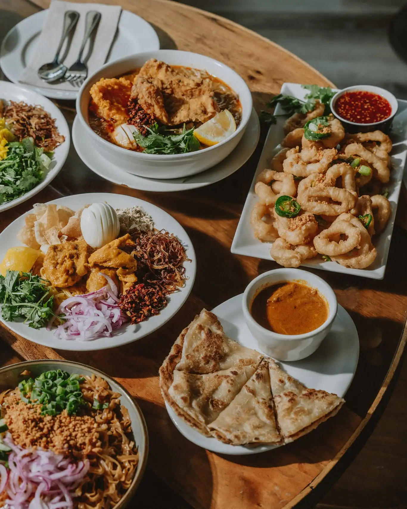 Burma Superstar Burmese food spread with tea leaf salad, platha, and calamari