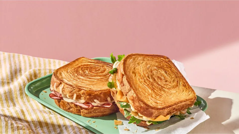 Panera croissant toast breakfast sandwich on a green plate for morning office catering