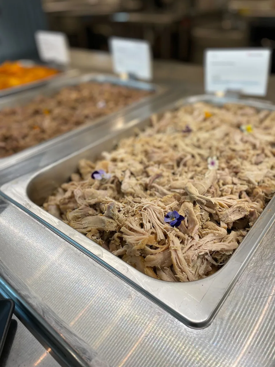 Office BBQ catering buffet with pulled pork, brisket, and sides set up on a drop-off line for a corporate event