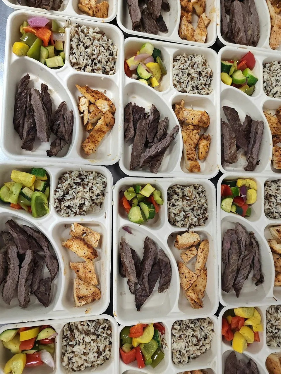 Overhead grid of identically packaged boxed lunches for a distributed team