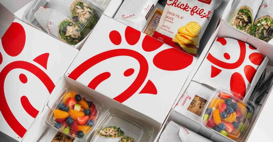Chick-fil-A packaged boxed meals with branded packaging, chips, cookies, wraps, and fruit cups