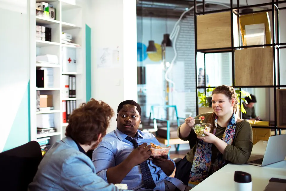 Office lunch spread with diverse dietary options including salads, grains, and labeled dishes