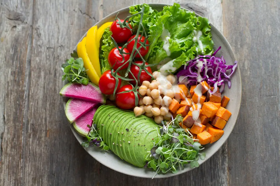 Colorful healthy grain bowl with avocado, chickpeas, sweet potato, and fresh vegetables