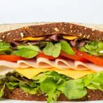 Fresh deli sandwich with turkey, cheese, lettuce, and tomato on whole grain bread