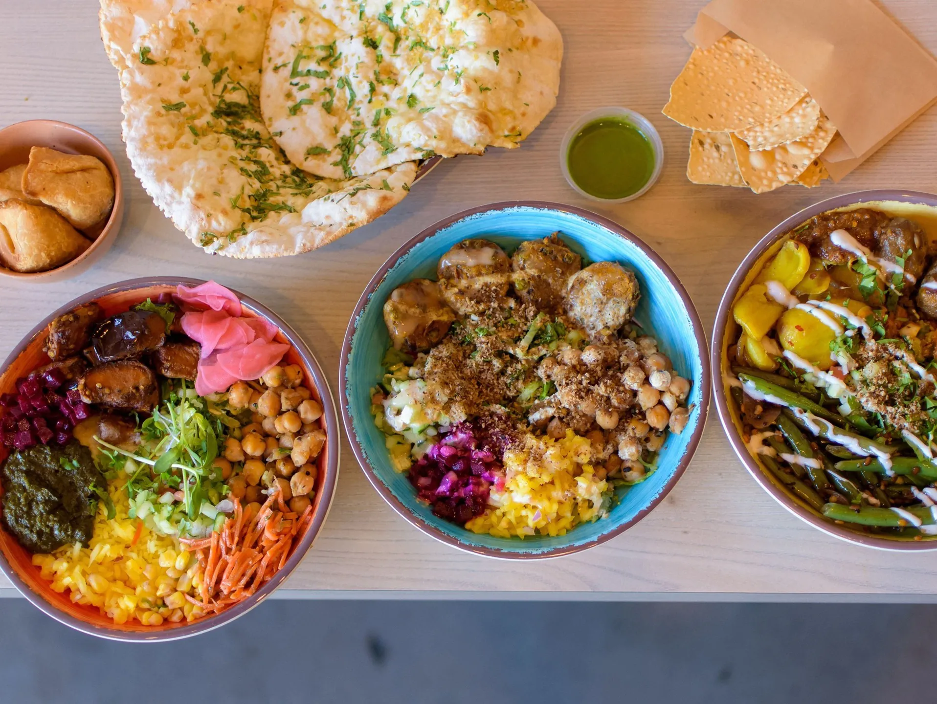 RASA Indian catering bowls with colorful curries, rice, and fresh toppings