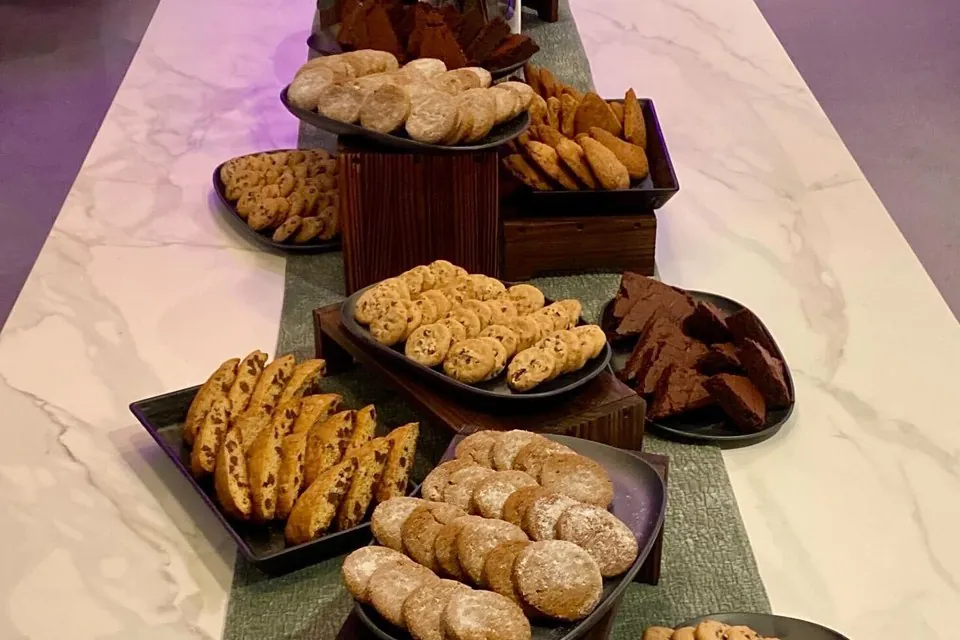 Tiered dessert display with cookies, biscotti, and brownies on marble for a full-service corporate event