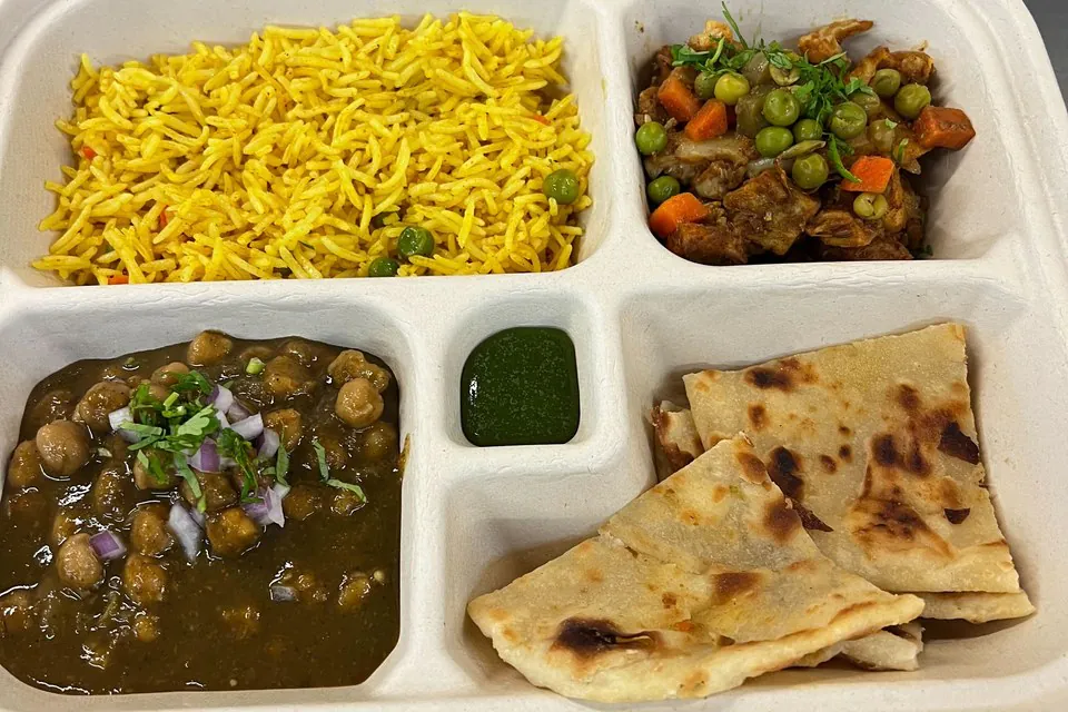 Individual compartment boxed lunch with basmati rice, chana masala, naan, and mixed-vegetable curry for D.C. office catering