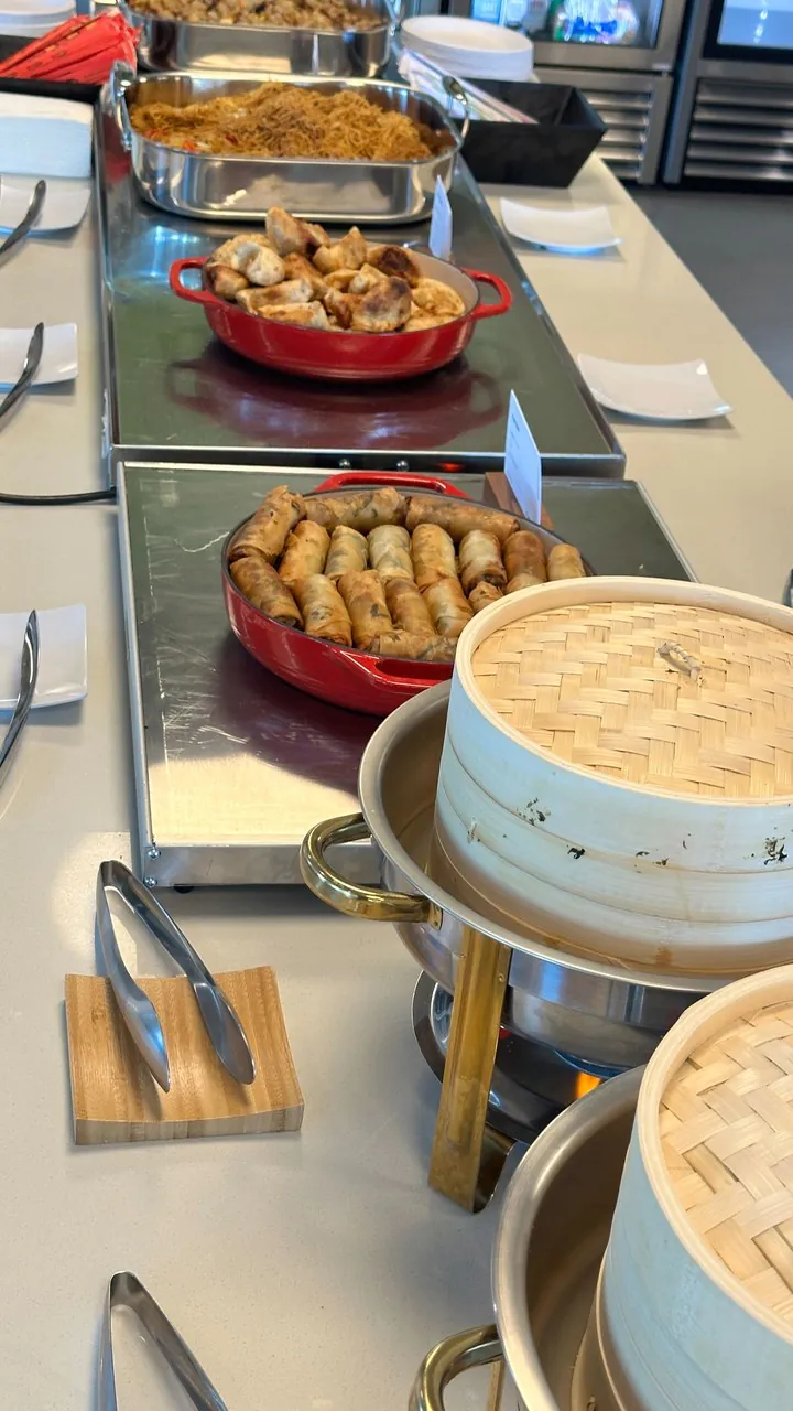 Panda Express style catering appetizer trays of chicken egg rolls, veggie spring rolls and fried rice in an office buffet line