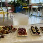 Bright modern Philadelphia office with corporate event buffet of charcuterie, cupcakes with orchids, and pastries.