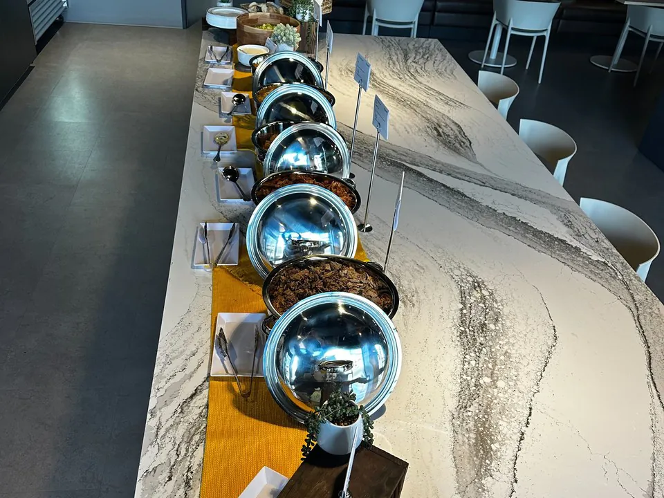 Elegant marble buffet line with stainless domed chafing dishes for a premium Dallas corporate event
