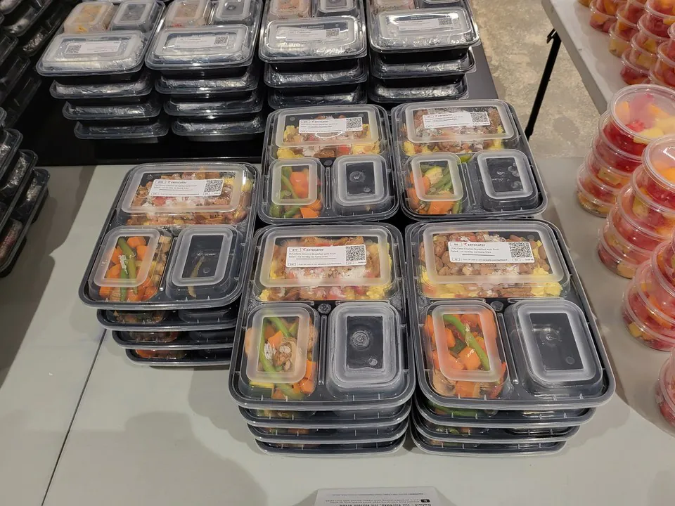 Stacked compartmented boxed meals with rice and roasted vegetables for Denver office catering