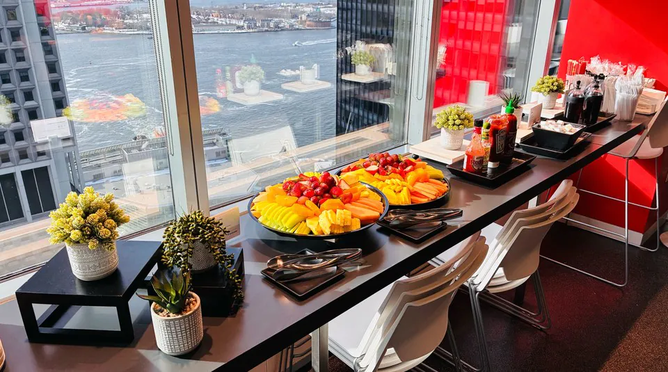 Fresh fruit platters of melon, berries, and pineapple on a bright window counter for a healthcare night-shift and morning-rounds breakfast spread