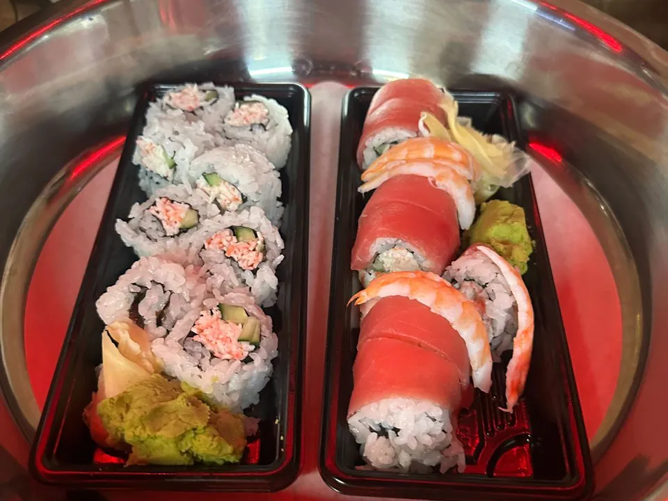 Two trays of fresh sushi and maki rolls with wasabi and pickled ginger on a silver platter