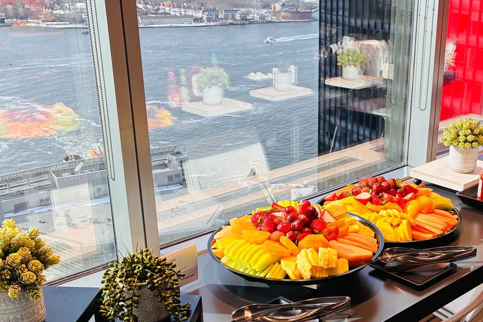 Fruit platters on a counter with a Seattle waterfront harbor view through floor-to-ceiling windows