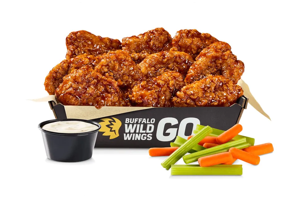 Catering box of saucy Buffalo Wild Wings boneless wings with a cup of ranch, carrots and celery