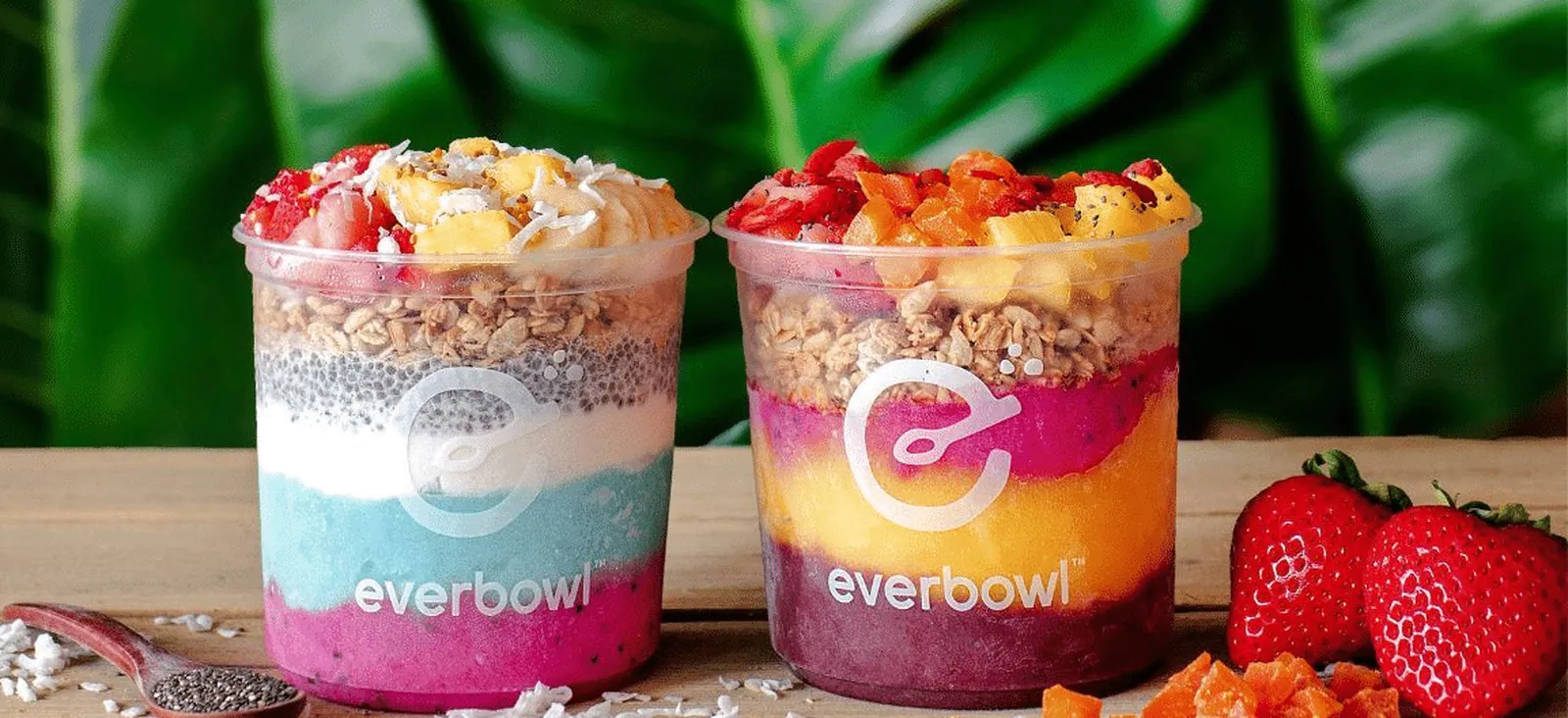 Two vibrant Everbowl craft superfood bowls in branded cups with layered acai, pitaya and blue majik bases topped with fresh fruit, granola and chia
