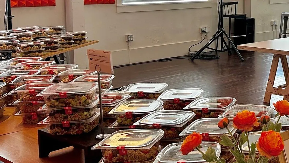 Rows of sealed individually boxed grain and salad meals labeled and ready for a desk-side office lunch
