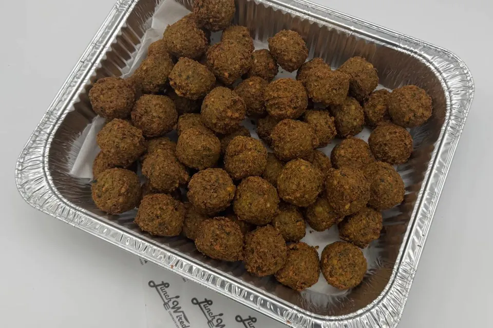 Half pan of Lunch Wired falafel on Lunch Wired branded paper