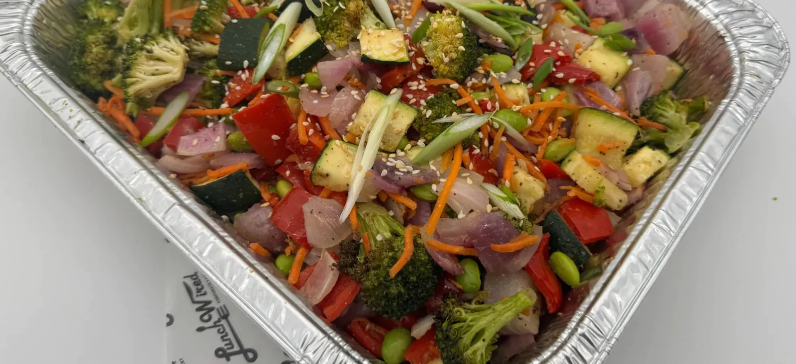 Half pan of Lunch Wired stir-fry vegetables with broccoli, zucchini, red pepper, carrot and edamame
