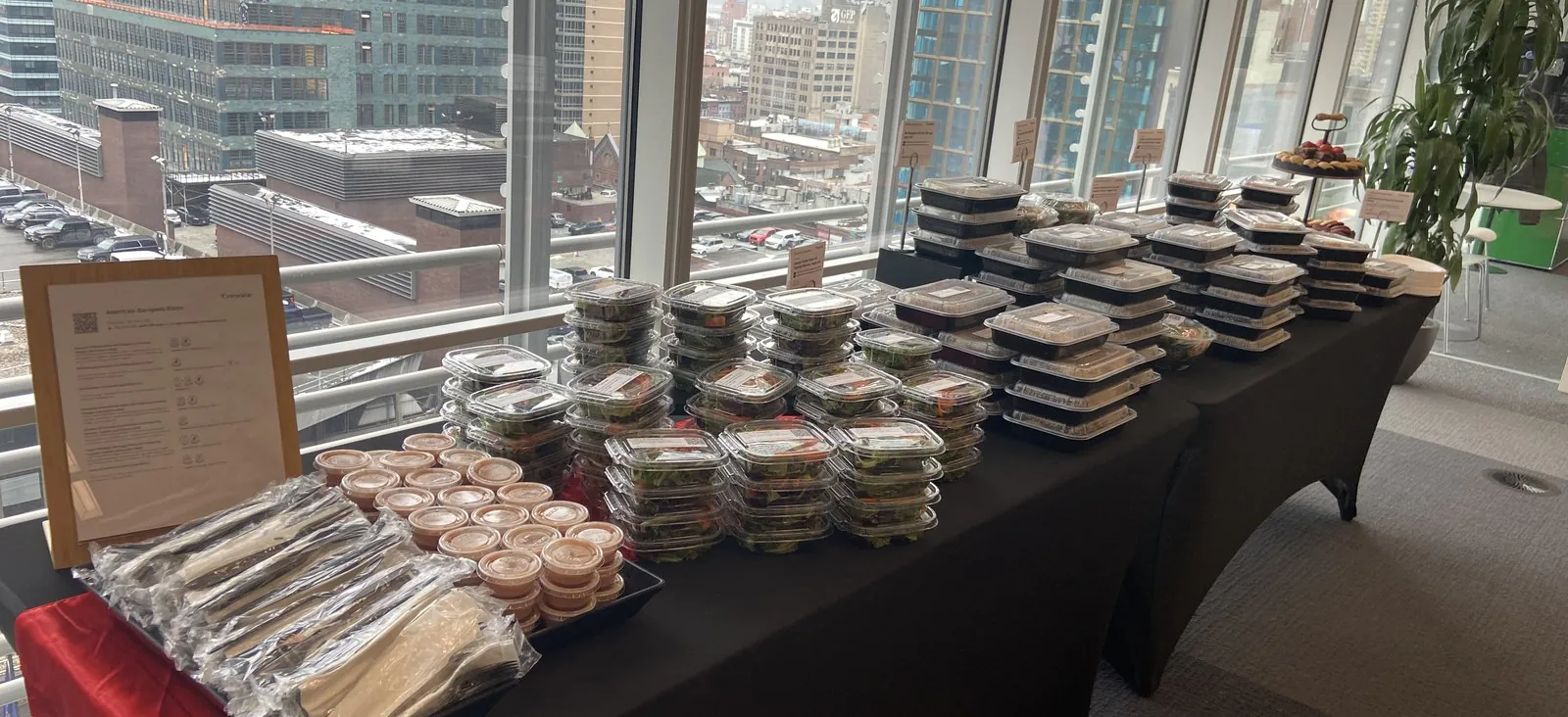 Long table set with rows of individually sealed boxed meals and wrapped cutlery for a large shift crew