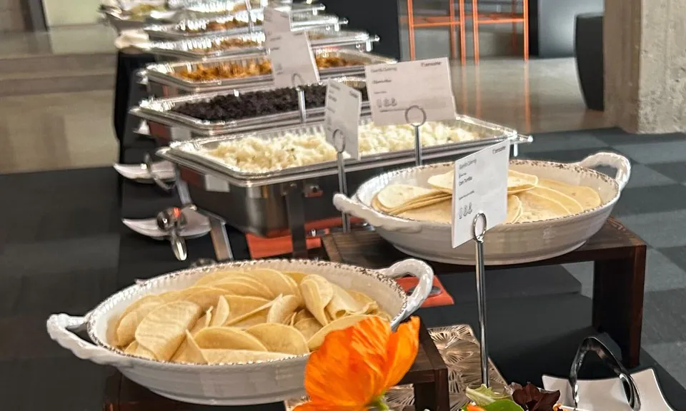 Buffet line with chafing trays, tortilla and chip bowls and serving utensils