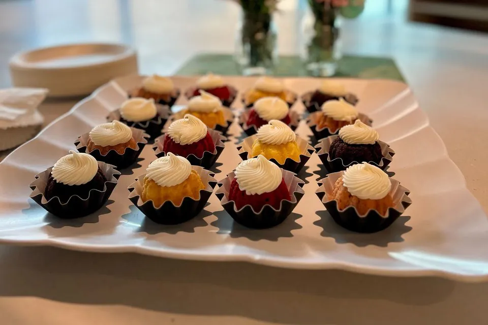 Individually portioned mini cakes in paper cups arranged on a white platter