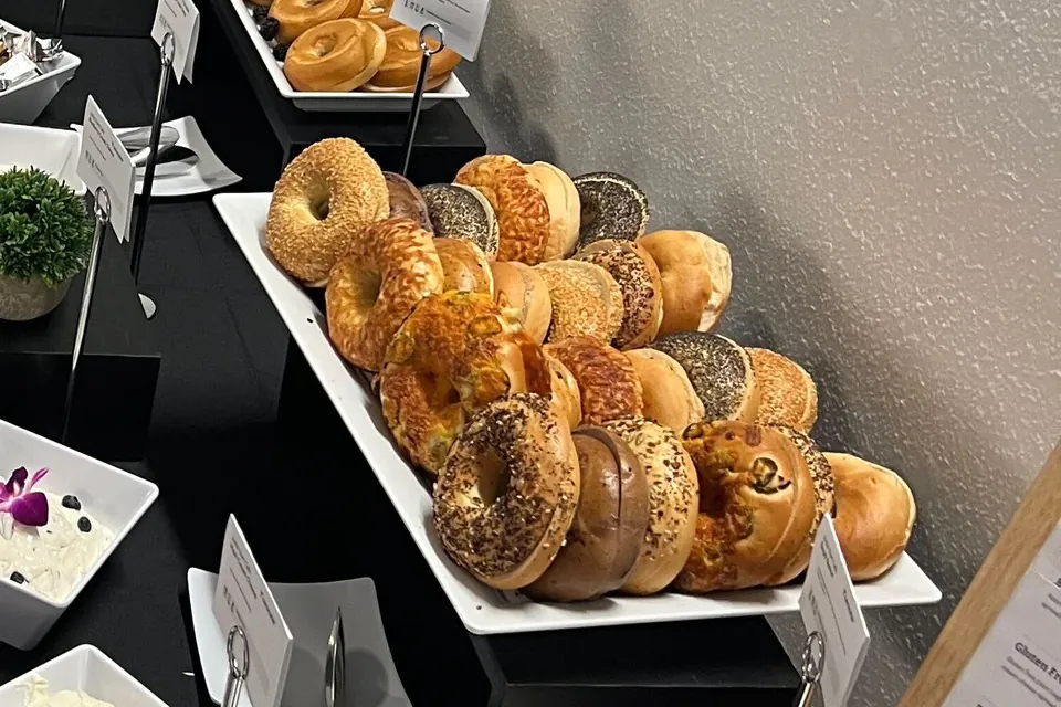 Bagel varieties on a Zerocater breakfast table A tray of bagels sorted by variety on a black-linen catering table