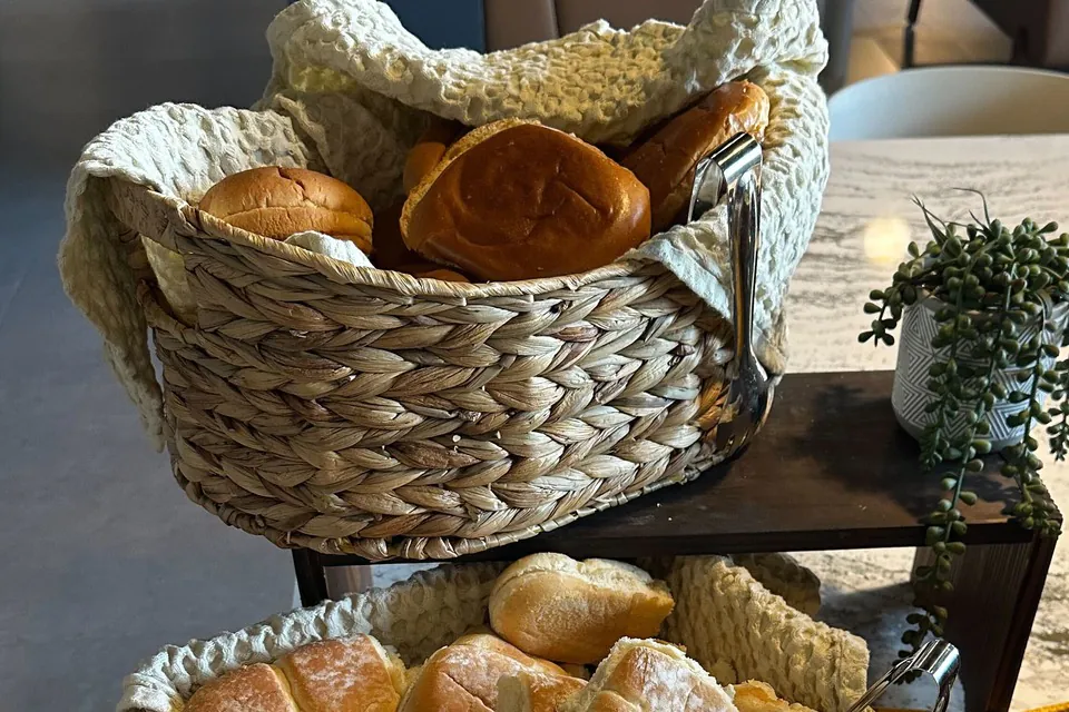 Two breads, two baskets, on a Zerocater office catering table Two woven baskets holding two different breads on an office catering table