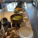 Office lunch buffet with a salad bowl, dinner rolls and chafing dishes