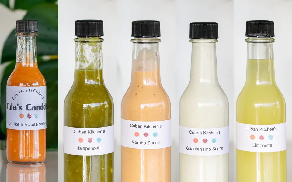 Cuban Kitchen house sauces Five bottles of Cuban Kitchen house sauces in a row: Tula's Candela, Jalapeno Aji, Mambo Sauce, Guantanamo Sauce and Limonette