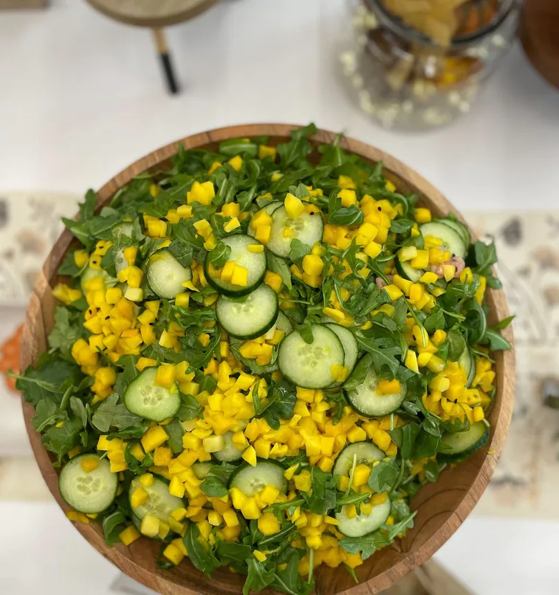 hero-healthy Overhead salad bowl with arugula, cucumber and mango at a catered office lunch